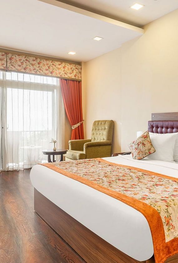 Deluxe room at Summit Barsana Resort & Spa, Kalimpong with a double bed