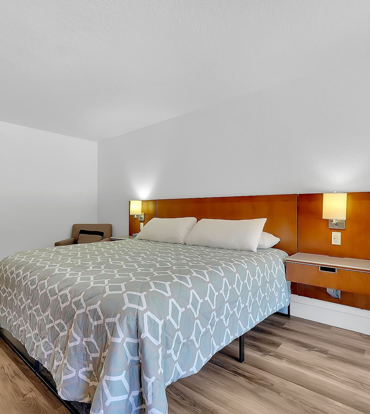 A view of a room at Amador Hotel with a double bed and side lamps.