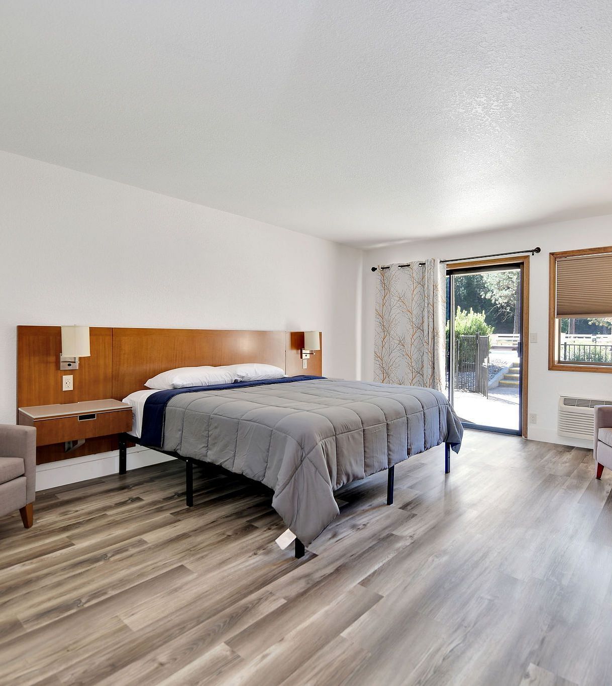 A view of a room at Amador Hotel with a double bed and a sofa chair.