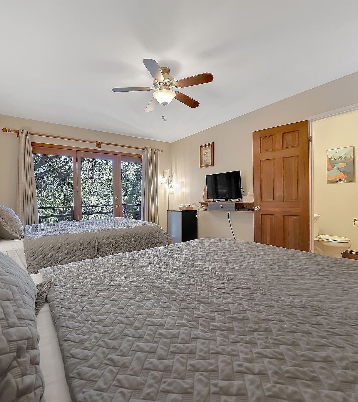 A view of a room at Narrow Gauge Inn with twin beds and a television.