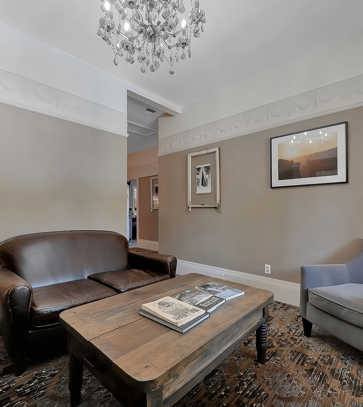 Living room area of a suite at The Groveland Hotel with sofa seating and a coffee table.