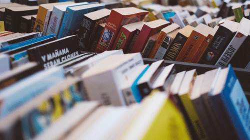 Stacks of books displayed at an outdoor book market.