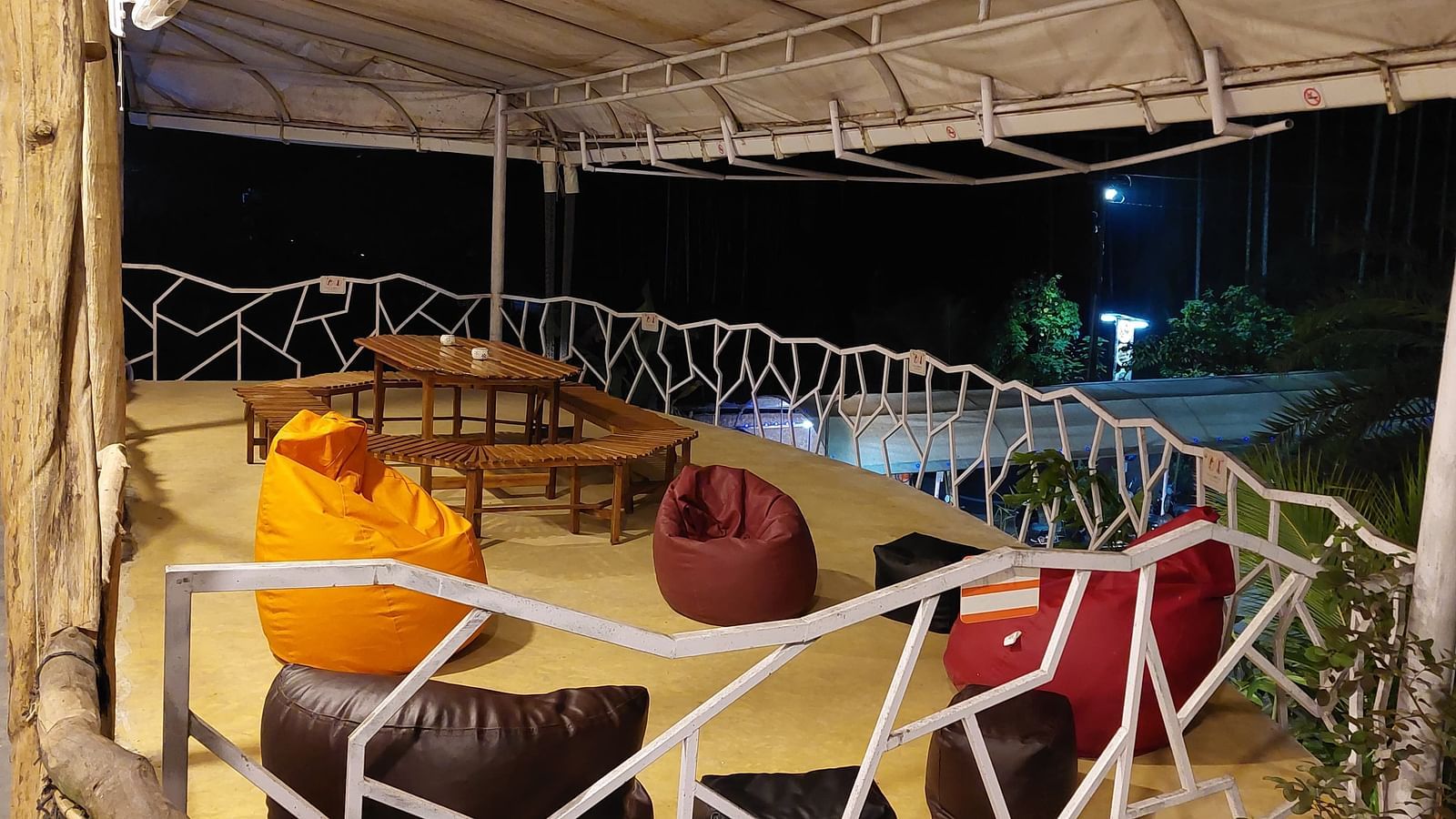 Relaxing outdoor lounge with colorful bean bags illuminated at night - Matsya Island Retreat by Island Quest.