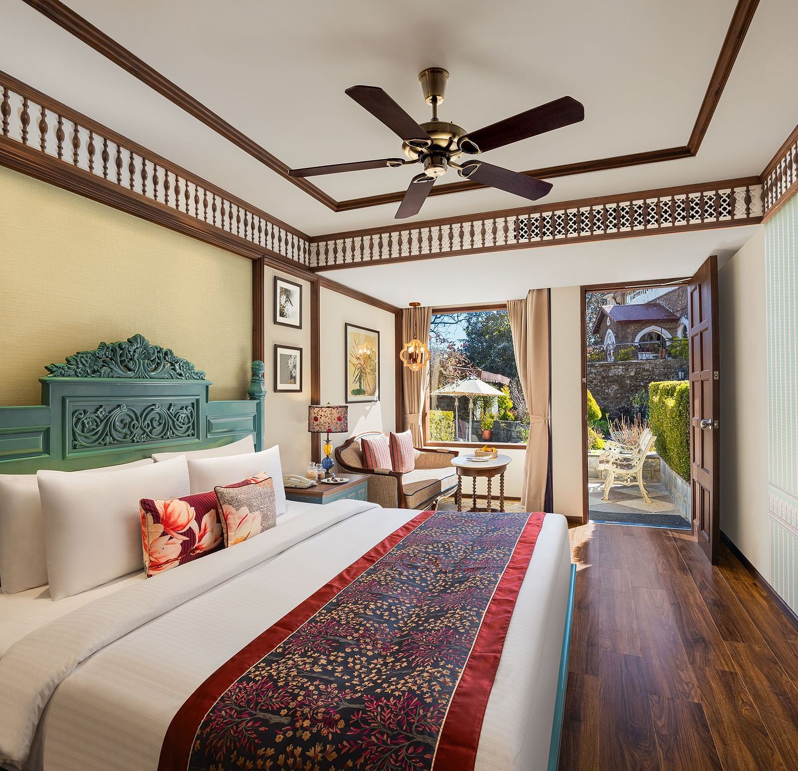 An image featuring premium Garden Room at naini retreat, nainital, A cozy and inviting hotel room with a king-size bed, The room features a small sitting area with a sofa and a side table, as well as a large window overlooking a garden.