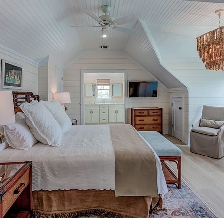 Spacious bedroom with a large bed, wicker furniture, and natural light | Abaco Inn