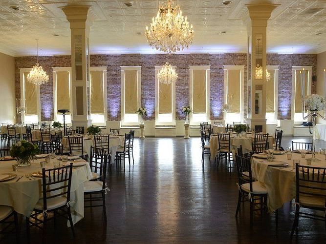 A luxurious dining hall featuring long tables with chairs and a grand chandelier, creating a refined and elegant atmosphere - The Grand Hotel & Ballroom, McKinney