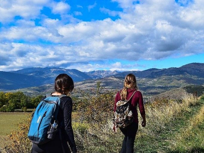 two women trekking on a hill