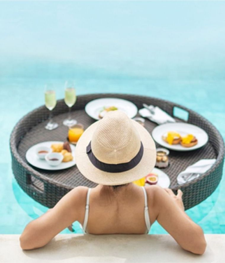 A woman having floating breakfast in the swimming pool at Nirvana Luxury Hotel, Ludhiana