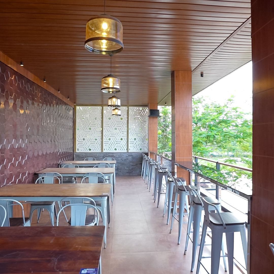 LOP dining area under the roof, featuring seating arrangements and ceiling lights at Sathyam Grand Hotels