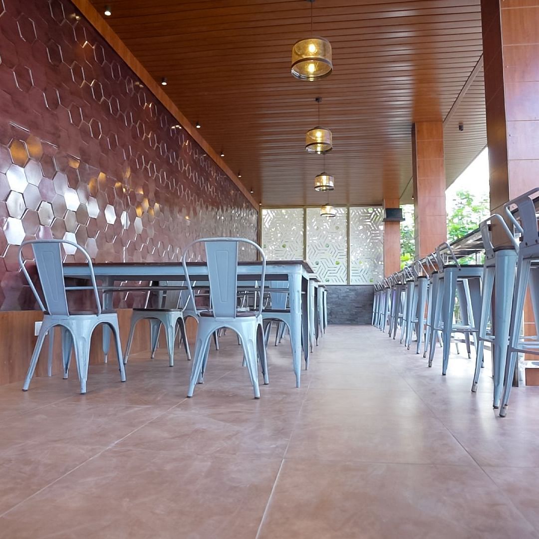 LOP dining area under the roof, featuring seating arrangements and ceiling lights at Sathyam Grand Hotels