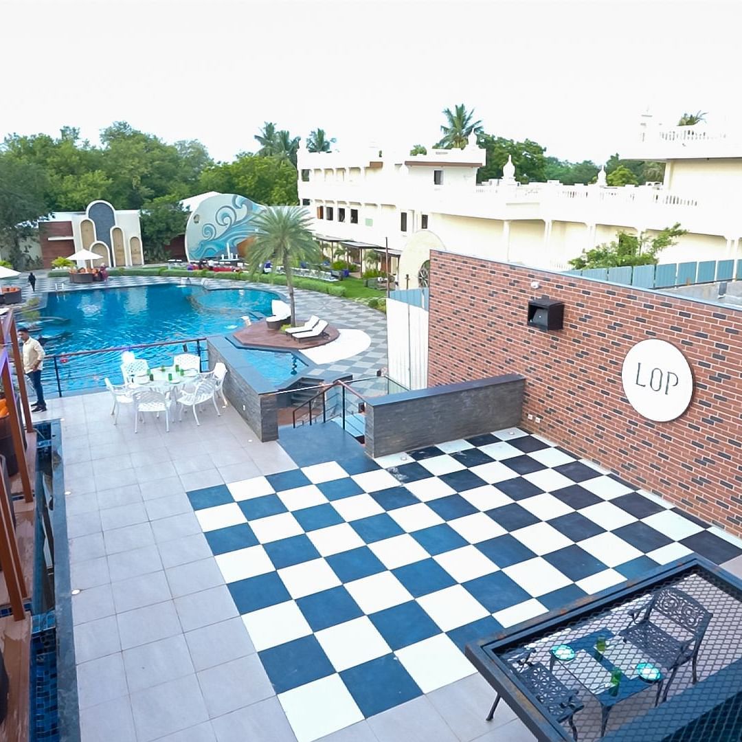 LOP, an open-top dining area with a swimming pool beside it at Sathyam Grand Hotels