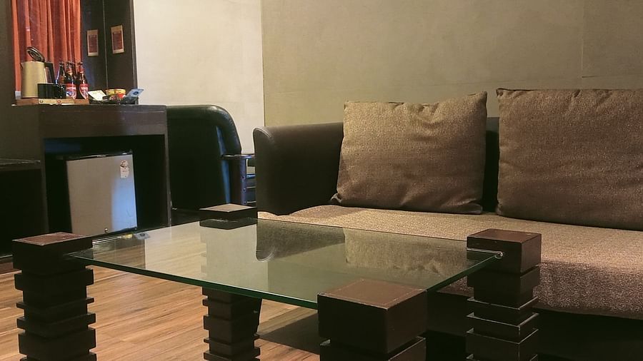 image of the centre table with a beige coloured couch behind it at the artist suite at grand palce yercaud