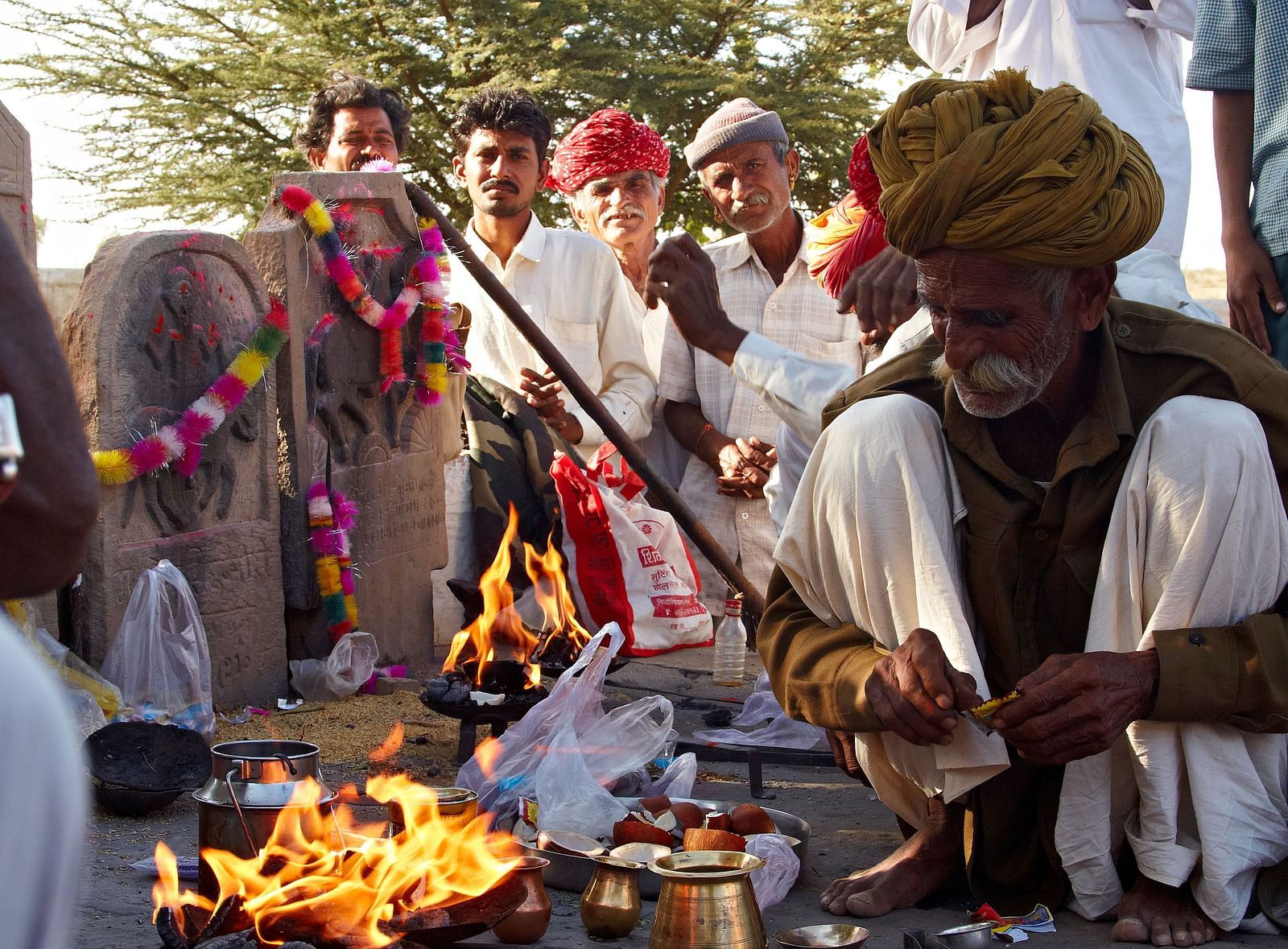 Local villagers cooking food in the open with a makeshift fire