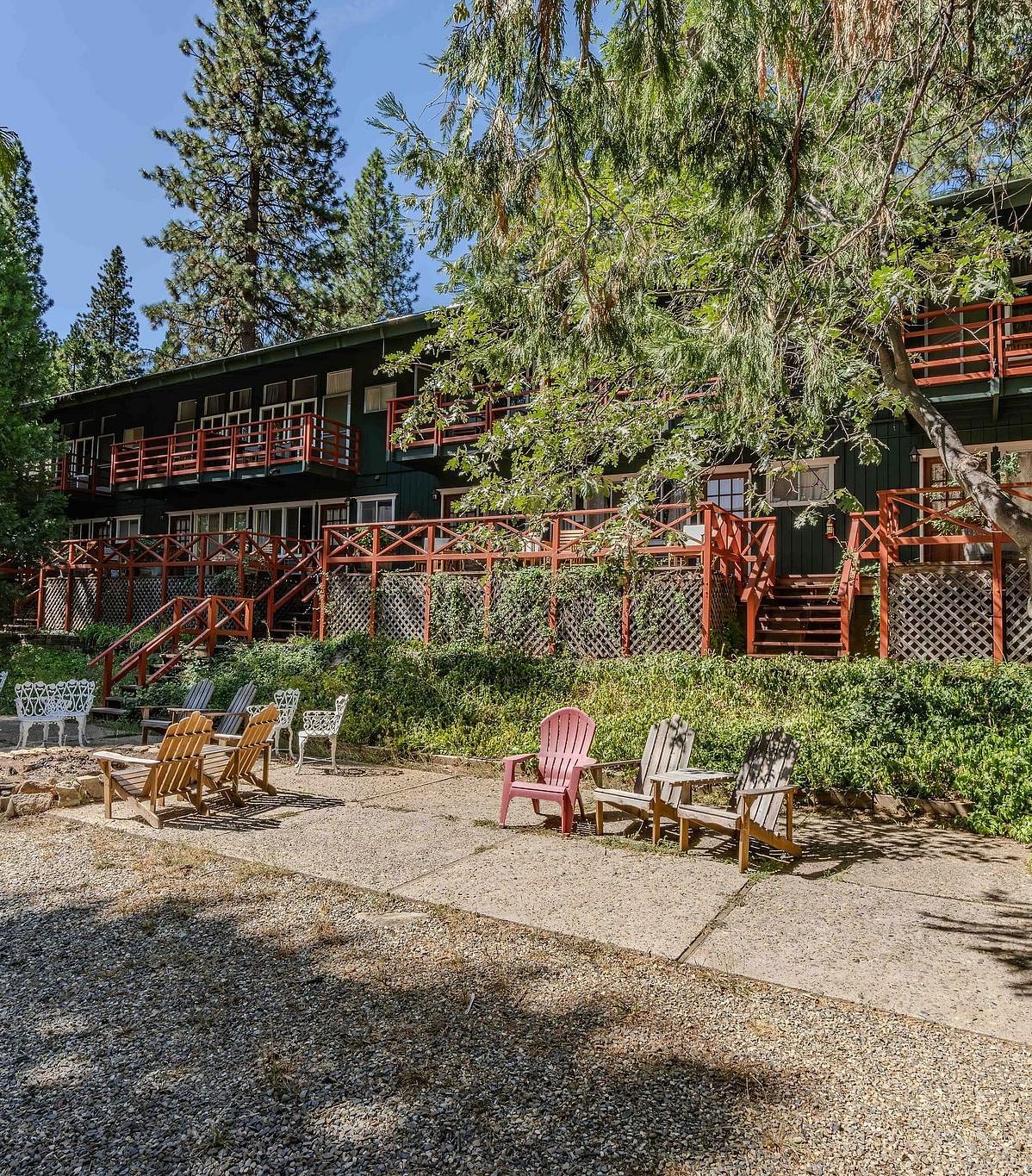 Seating in front of the facades of cabins with forest green exteriors at Narrow Gauge Inn.