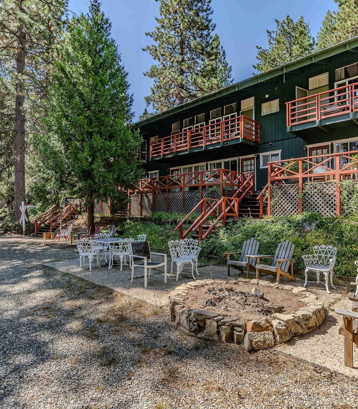 Outdoor seating in front of the cabin at Narrow Gauge Inn surrounded by trees.