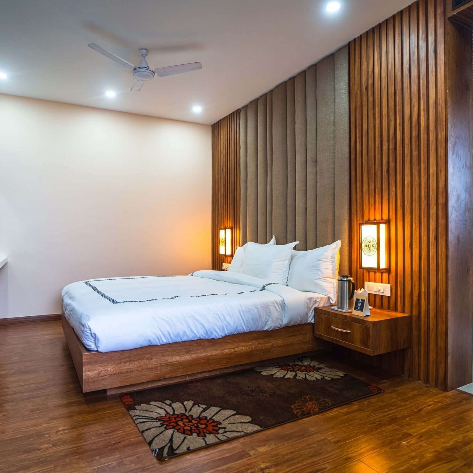 A comfortable bedroom at Mansha Palace opens into a separate living area with a sofa and wall art.