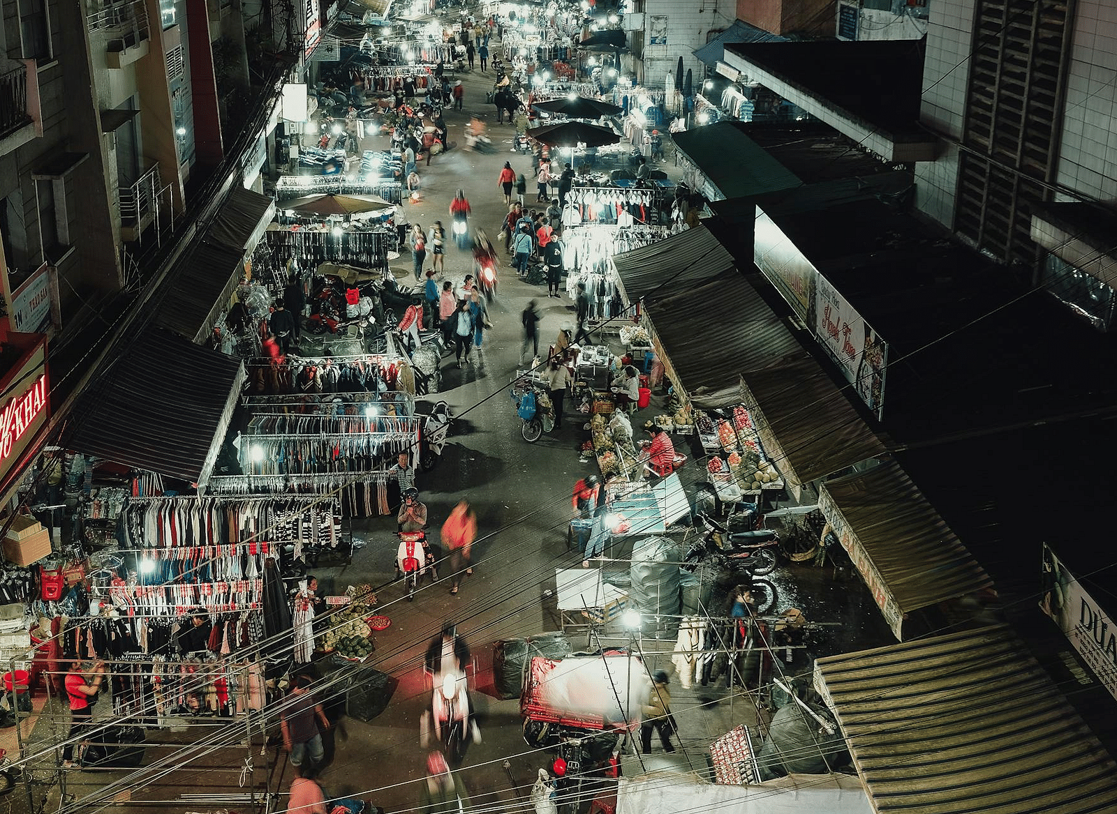 Top view of a street with people strolling and shops lining both sides.