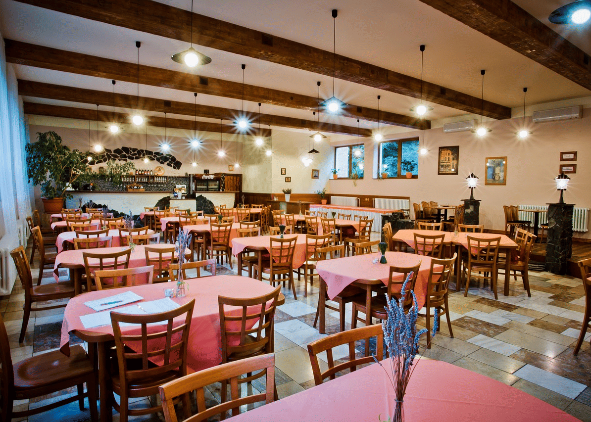 Spacious dining hall at Paradise Wild Hills Resort featuring colorful seating, exposed beams, and bright ambiance.