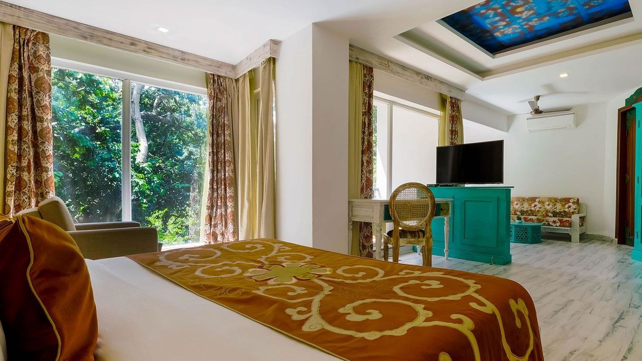 Side view of a bedroom with bed and modern amenities at Summit By The Ganges Beach Resort & Spa, Rishikesh