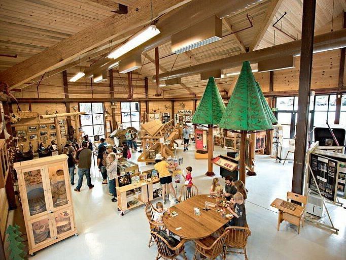 Interiors of a museum with large wooden beams and a sloping roof line - Shaver Lake Village Hotel.