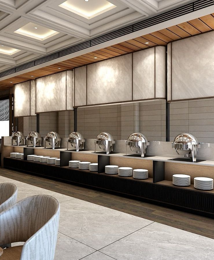 The buffet counter with various porcelain plates lined up together right behind the dining area of the restaurant - Namaste Corbett