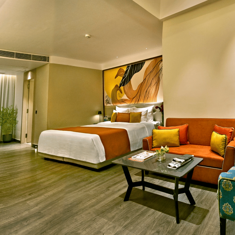 Spacious suite with living area, green seating and modern design at The Sonnet, Jamshedpur.