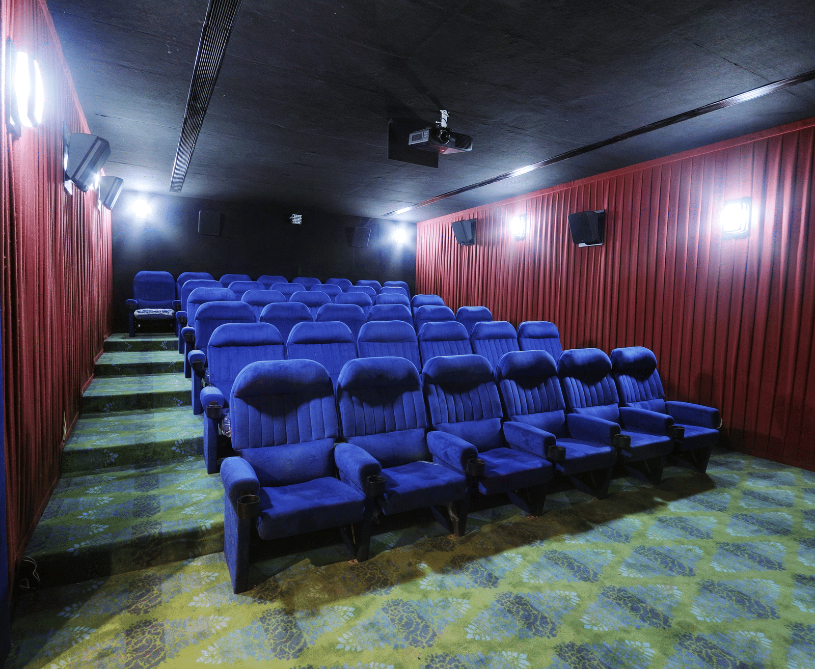 Private theatre with rows of blue seats and red wall panels – Narayani Heights Hotel & Resorts