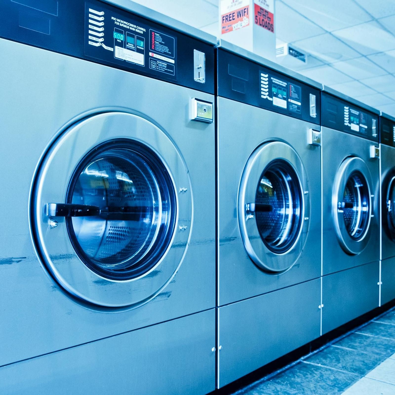 A row of several front-load washing machines.