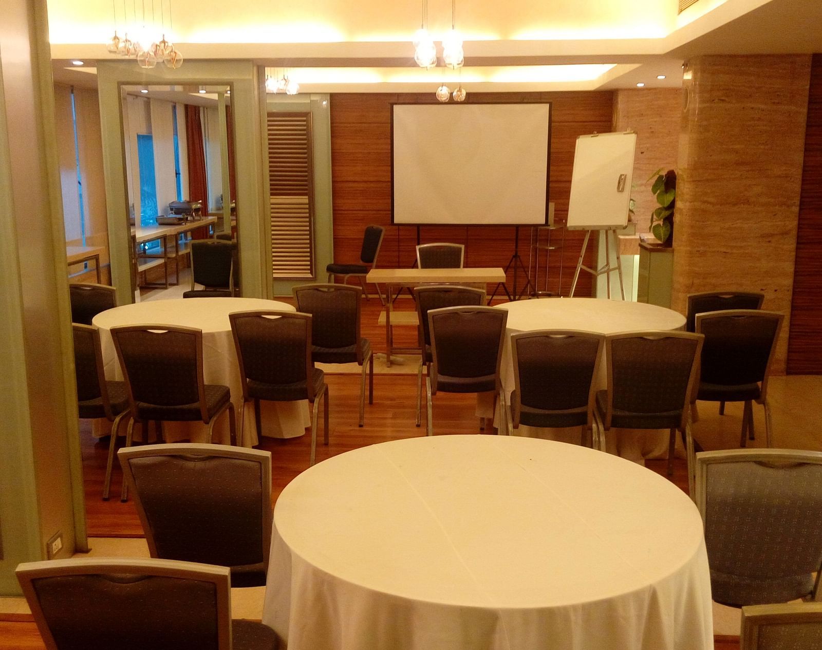 Image of a banquet hall at Mirage Hotel featuring round tables and brown chairs | Mirage Hotel 