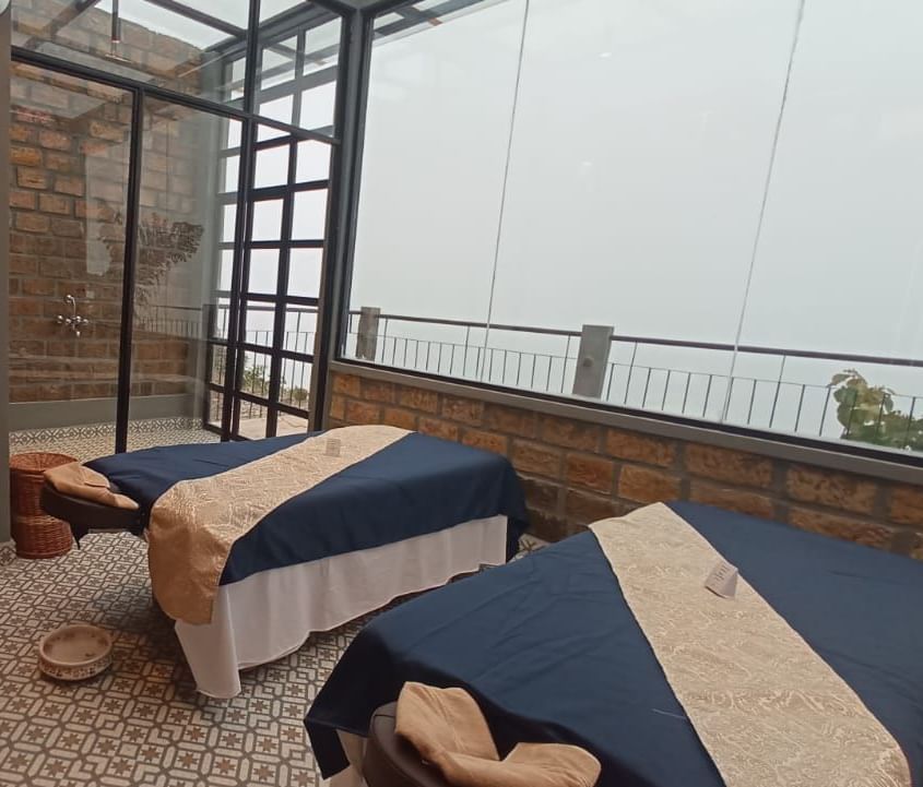 Spa room with massage beds and glass windows at Polo Resort Cherrapunjee.