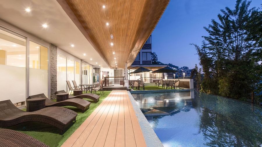 A night time view of a pool with sun loungers placed on its deck - Summit North Star, Gangtok