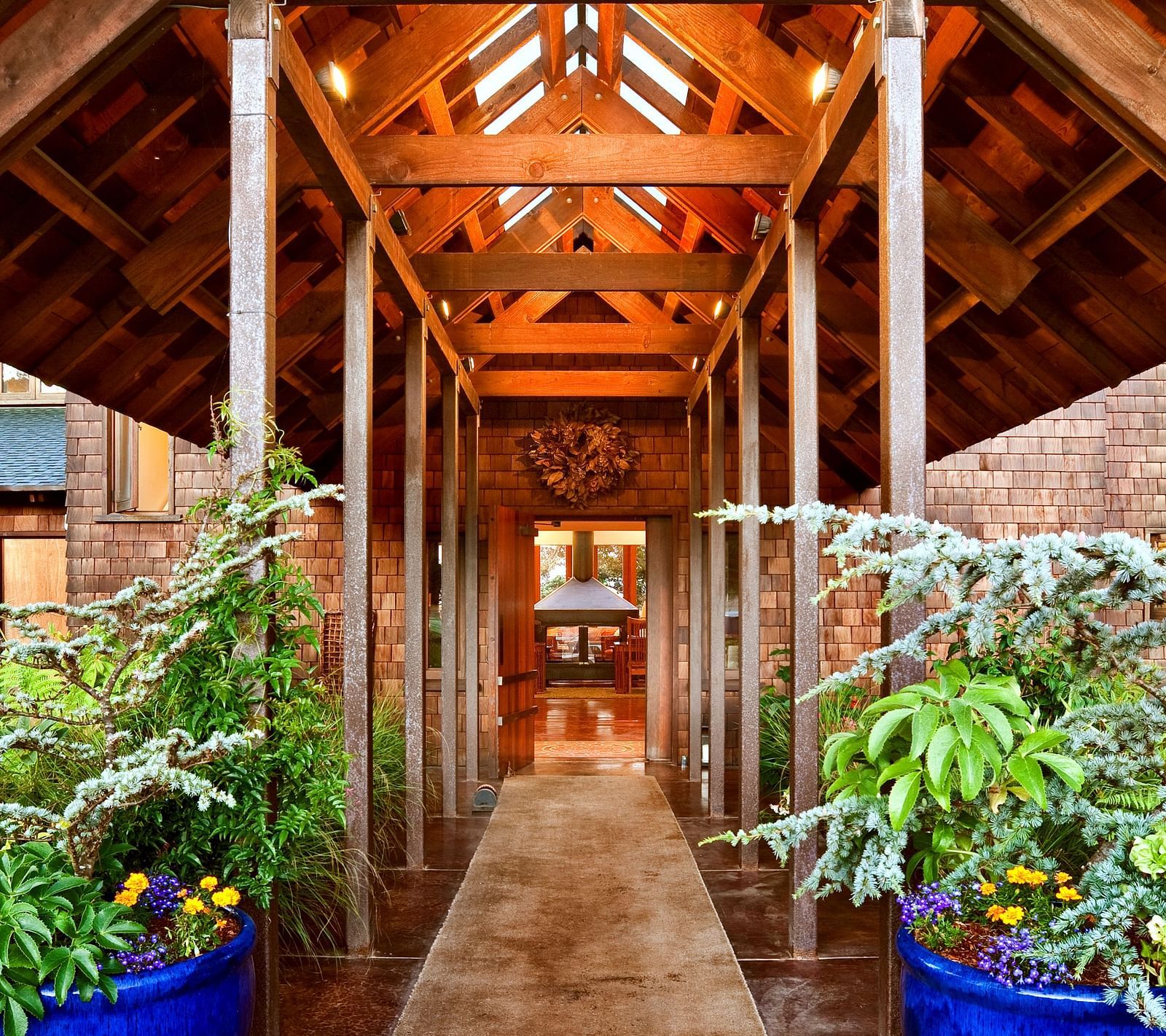 The rustic, wooden entrance to our Inn surrounded by greenery and illuminated by natural light - Brewery Gulch Inn & Spa