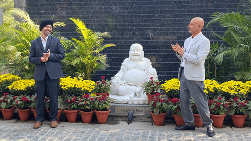 A group of people talking in front of potted plants - Karma Lakelands.