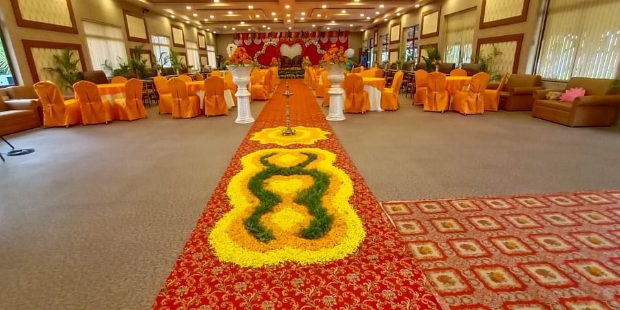 Extended view of the large banquet hall of GK Hill View Resort furnished with round seating tables and chairs.