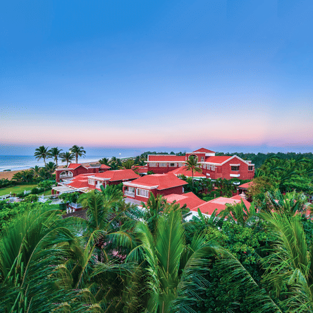 High-angle view of the iconic red-roofed villas at MAYFAIR Heritage Puri overlooking the coastal greenery.