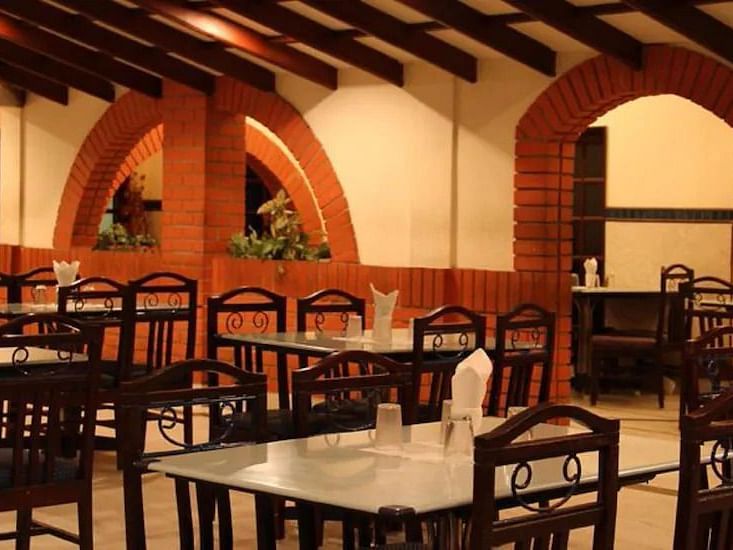 Side view of restaurant Mayura, which has multiple chairs and casual ambience - Hotel Ram International,  Pondicherry