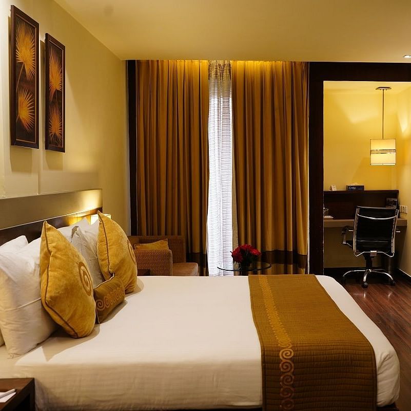 Club Room decked with a comfy bed, a television and a work desk at Shervani Nehru Place, New Delhi