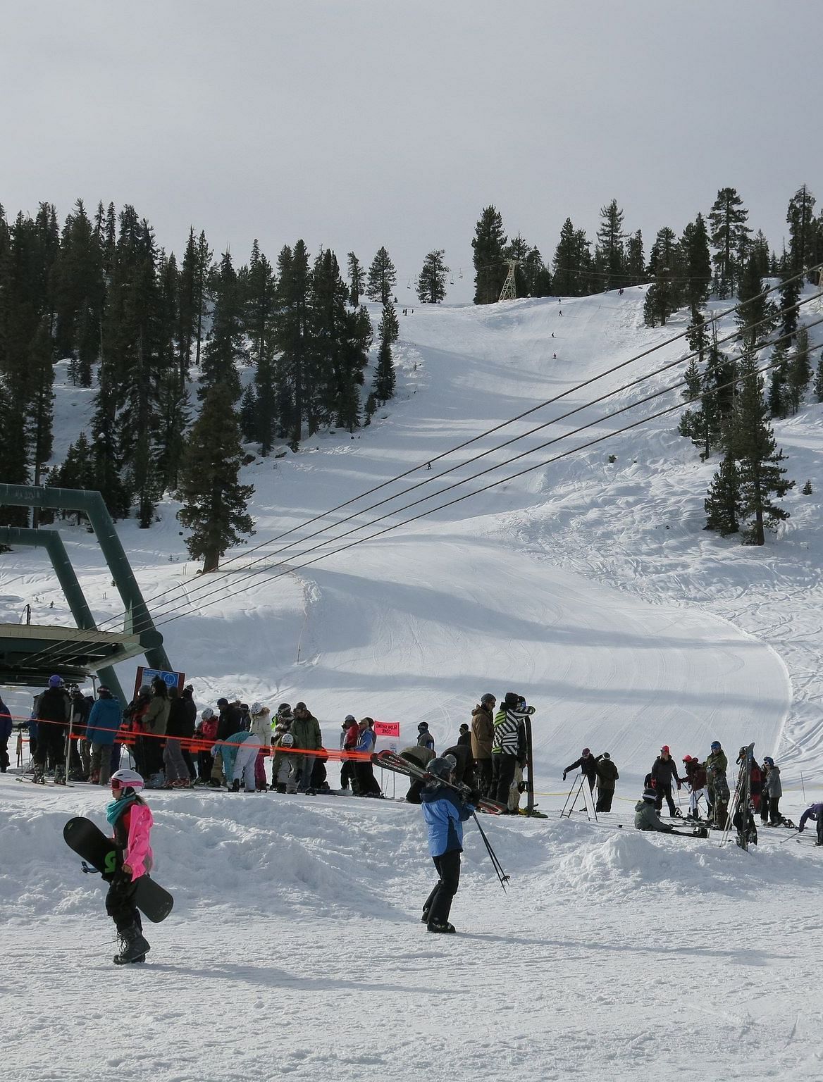 People skiing on a snowy mountain on an overcast day.