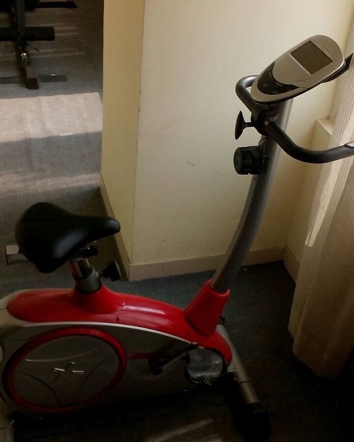 Gym equipment placed near a window with curtains - Lords Plaza Ankleshwar
