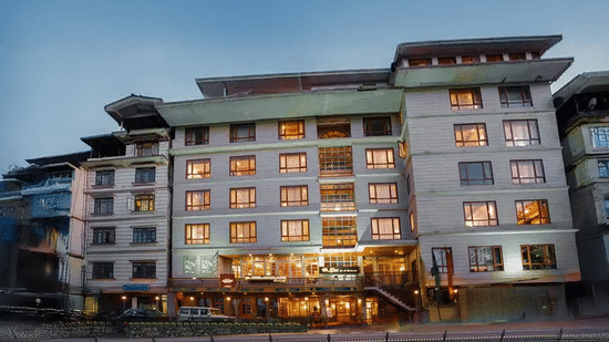 illuminated hotel facade at dusk, showcasing multiple floors and warm interior lighting.  