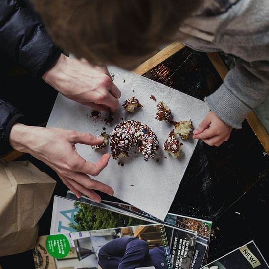 two people having their hands on a dessert kept on a table