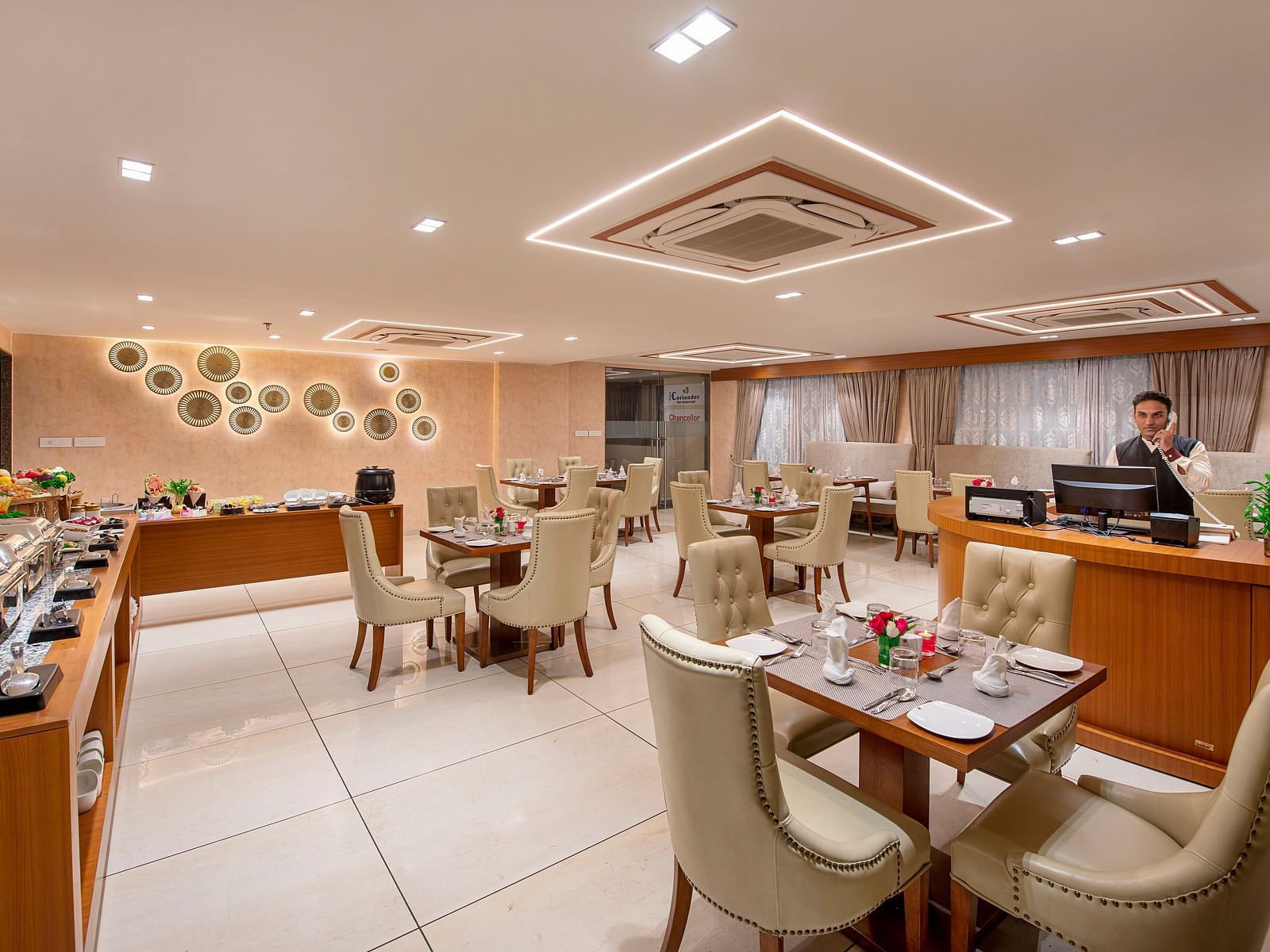 A view of a hotel dining space, showing a mix of table setups - SK Lords Inn Ahmedabad