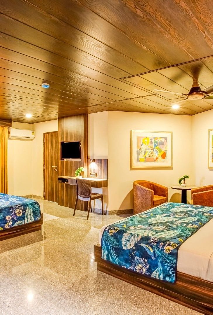  Family room with a private balcony featuring two beds, ceiling fans, and large framed photographs