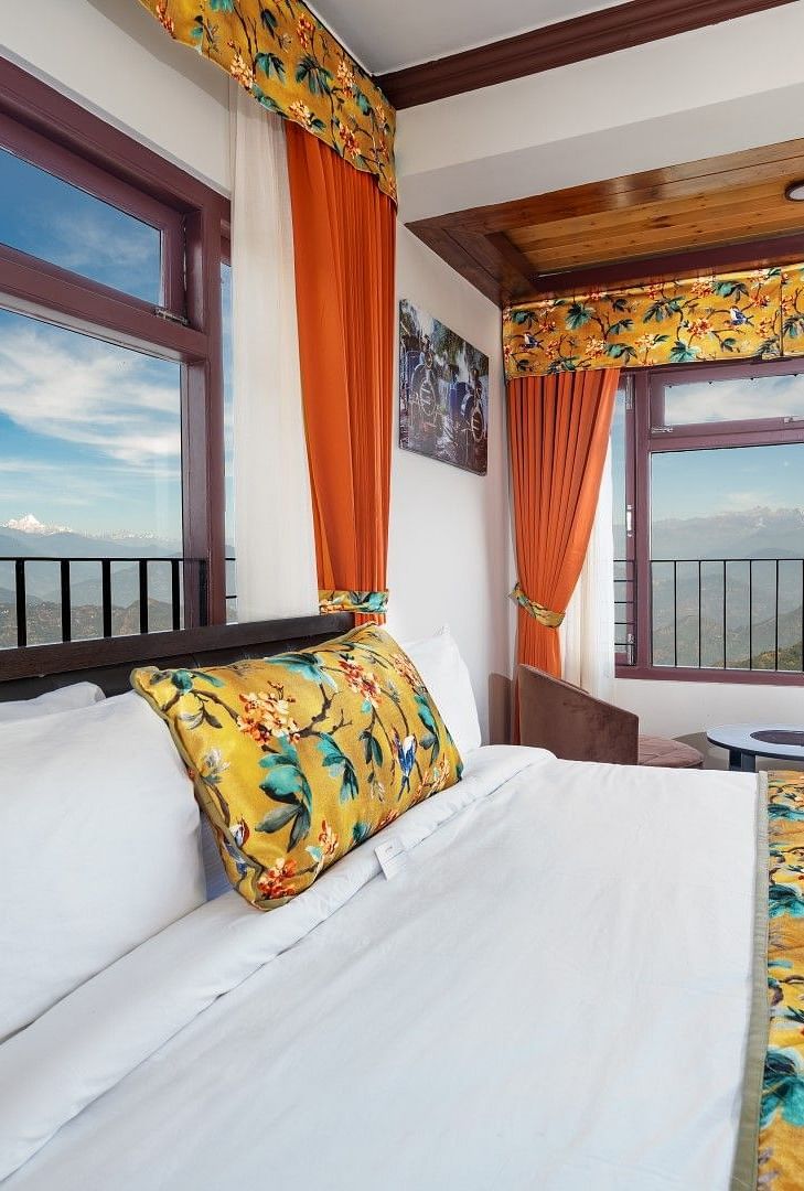 Image of a room with bed and two large windows with view of the mountians at Summit Sherpa Mountain Hotel & Spa, Kalimpong