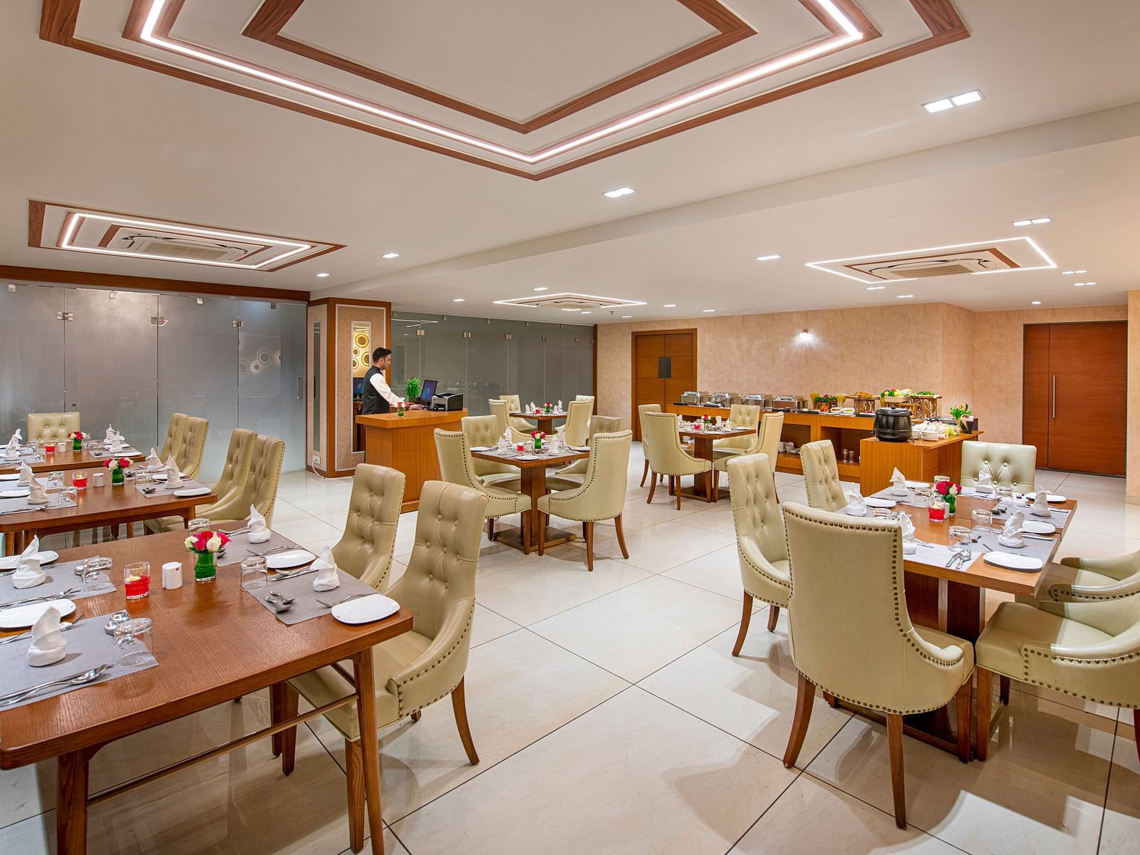 A hotel dining area with wooden tables and comfortable chairs, ready for guests to dine - SK Lords Inn Ahmedabad