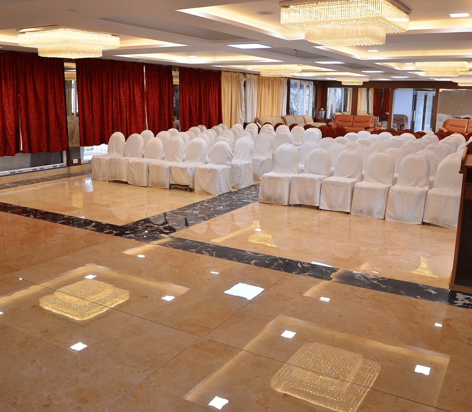 A spacious banquet hall with a stage setup and ample seating for formal gatherings and events - Benzz Park, Kodaikanal
