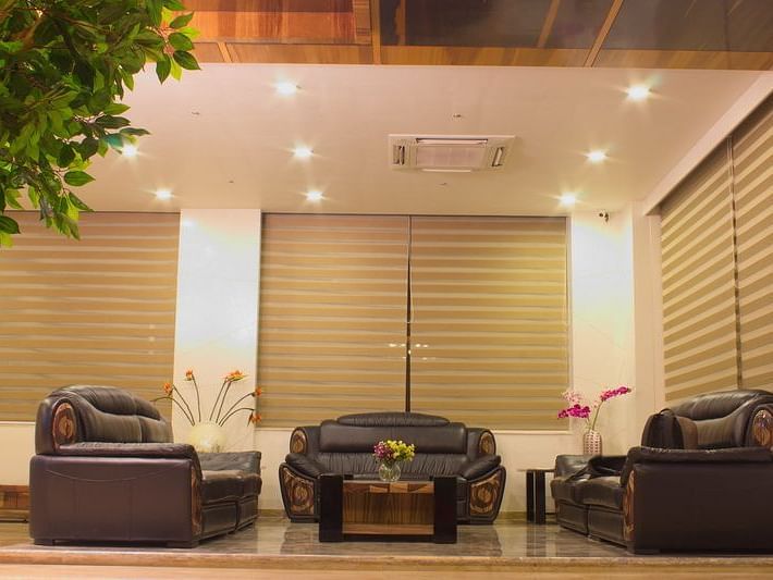 An inviting hotel entrance or lobby at Lords Inn Porbandar, with modern seating and natural light filtering through blinds.