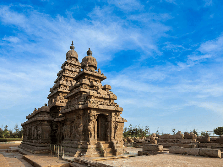 An ancient stone temple with intricate carvings under a blue sky.