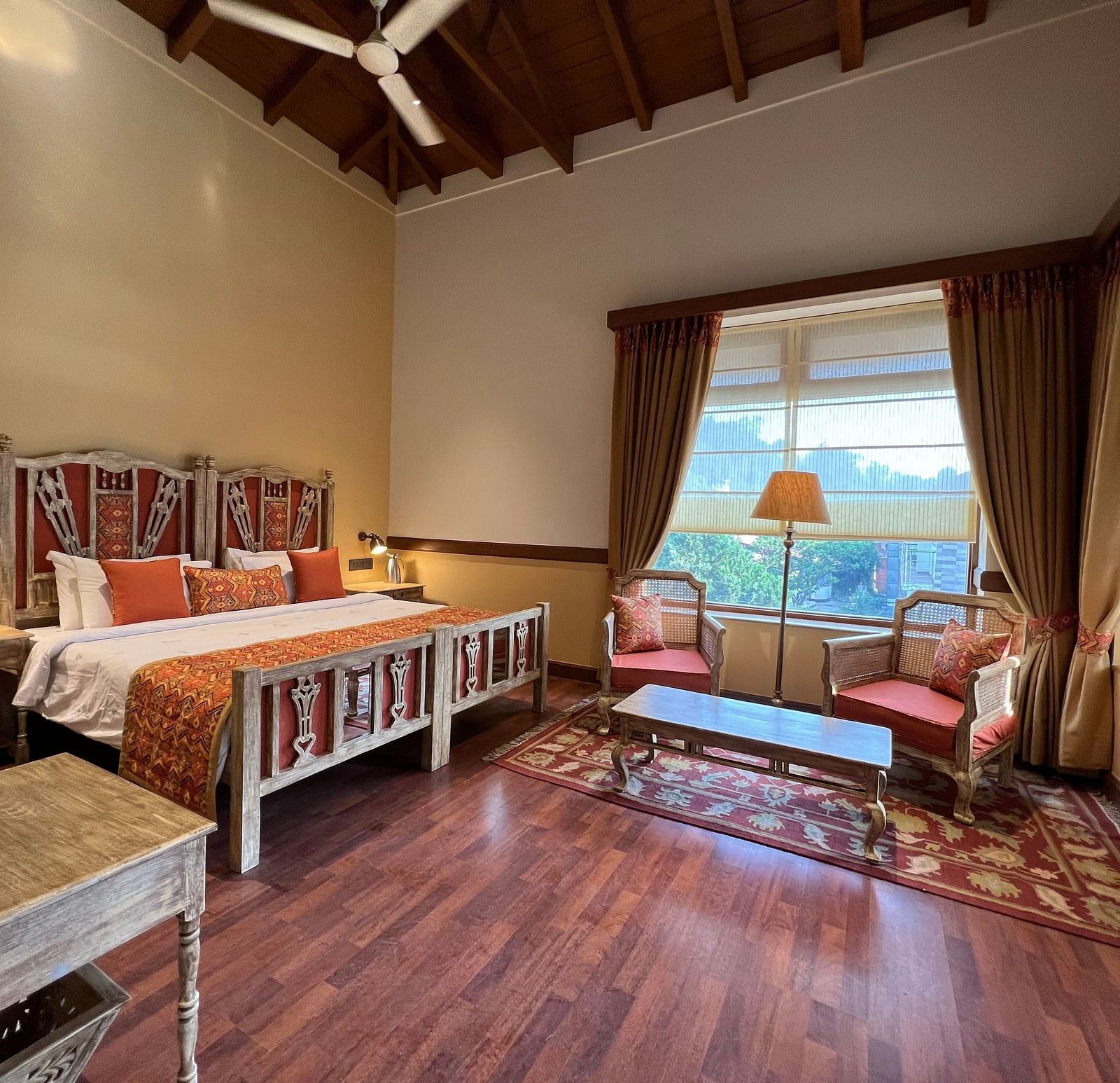  A comfortable Superior Lake Facing Room at Fishermen's Lodge, Bhimtal, featuring a wide open window with stunning views of the lake and surroundings.