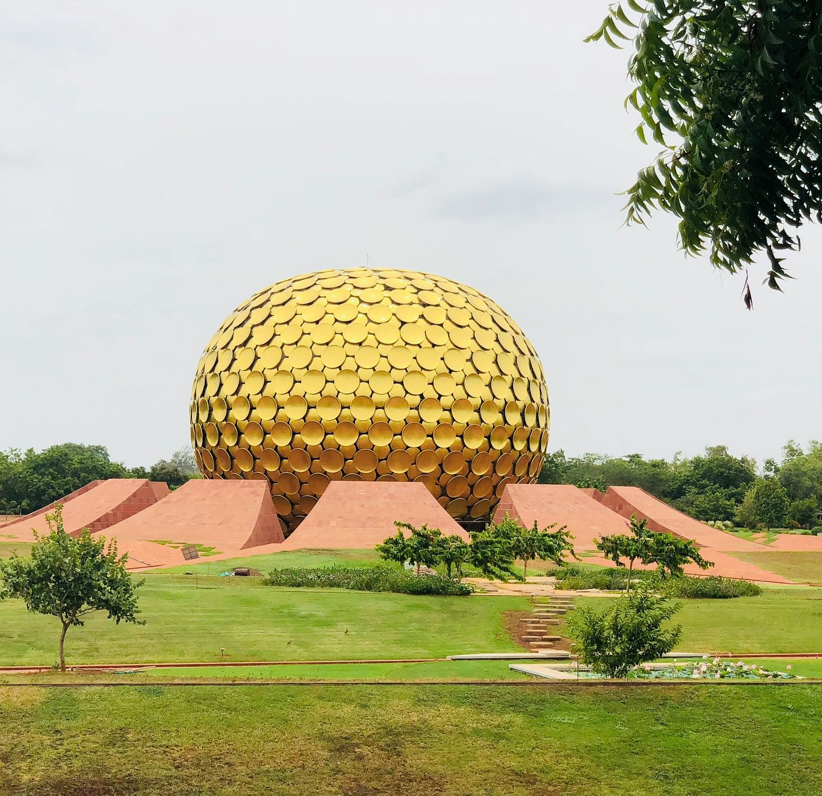 The golden dome in Aurovilla in view with manicured garden surrounding it